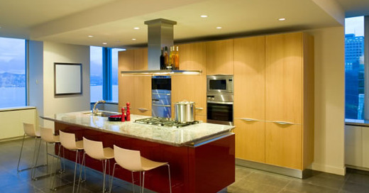Фото интерьера кухни с большими вместительными шкафами, встроенной печью и столом барной стойкой